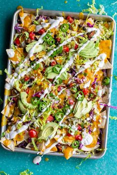 a tray filled with taco salad on top of a blue table