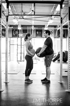 a man and woman standing next to each other in a gym holding their hands together