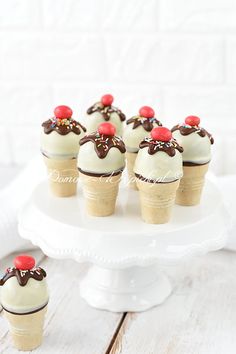 small cupcakes with chocolate frosting and cherries on top