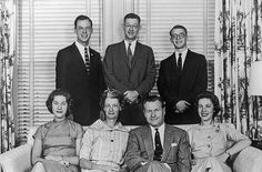 a group of men standing around a table with wine glasses and plates in front of them