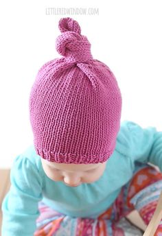 a small child wearing a pink knitted hat