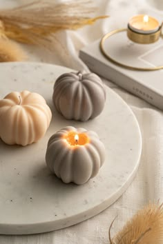 three candles sitting on top of a white plate