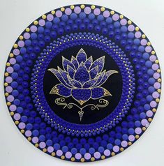 a blue and purple plate with a flower on the center, surrounded by circles in gold