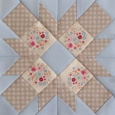 a blue and white quilted design with flowers on the center is featured in this image