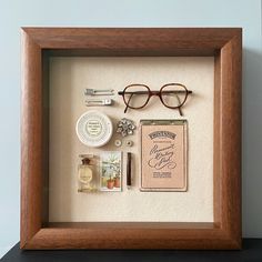 a wooden frame with some items in it on top of a table next to a wall