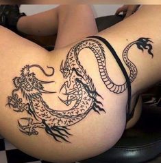 a woman with a dragon tattoo on her thigh