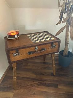 a wooden table with a chess board on it and a potted plant next to it