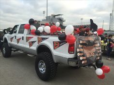 a truck with balloons and decorations on the back