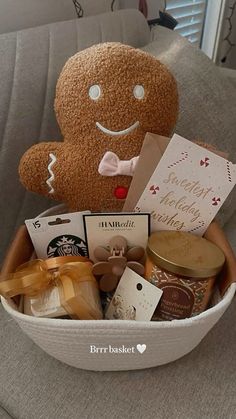 a stuffed teddy bear sitting in a basket filled with food and candys on top of a couch