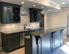 an empty kitchen with granite counter tops and stainless steel appliances, along with dark wood cabinets