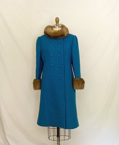 "One of my favorite finds ever! This coat is gorgeous and in wonderful condition. Thick wool turquoise blue outer later, double breasted with pretty diamond-shaped buttons. Fur on the collar and cuffs is real, probably mink, very soft. Collar fastens with hidden snaps and a hidden toggle at the left shoulder. Side pockets. Fully lined in blue satin. Half-belt (or Martindale) with buttons at the back waist. There are no tags, though this seems professionally made. Placing it some time in the sixt Fitted Turquoise Outerwear For Winter, Coat With Fur Trim, Blue Wool Coat, Medium Coat, Coat With Fur, Thick Wool, 60s Mod, Mod Fashion, Vintage Coat