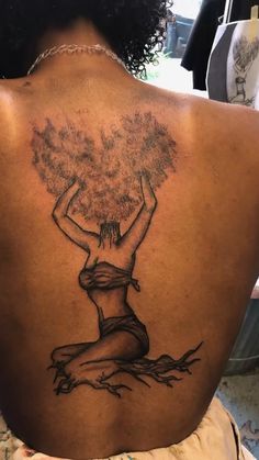 a woman with a tree tattoo on her back