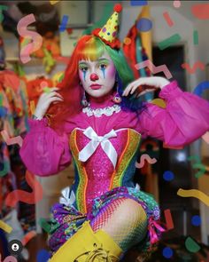 a woman dressed as a clown sitting on top of a wooden floor with confetti all around her