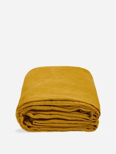 the mustard colored blanket is folded on top of each other, and it's very soft