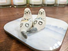 two ceramic birds sitting on top of a wooden table