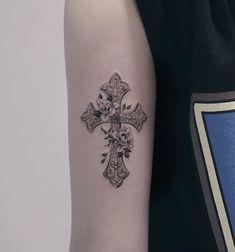 a cross tattoo on the left arm