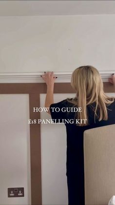 a woman is painting the wall with white paint and she has her hands on the paneling