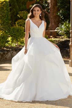 a woman in a white wedding dress posing for the camera