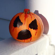 a painted pumpkin sitting on top of a white ledge