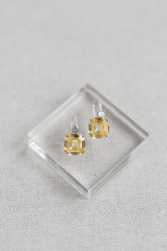 "With the look of luxury fine diamonds, the sparkle and presence of the Astor luxury earrings are something to behold. Small brilliant cut crystals cascade along the French hook style earpiece with a small brilliant cut crystal settling on top of a magnificent sparkling canary yellow asscher cut crystal. Beautifully realistic and elegant enough for everyday wear and also for evenings out and special occasions. The Asscher cut is a unique shape with prismatic brilliance and a rectangular-faceted Elegant Asscher Cut Diamond Accent Earrings, Elegant Asscher Cut Earrings With Diamond Accents, Asscher Cut Diamond Accent Earrings For Wedding, Elegant Diamond Earrings With Asscher Cut, Diamond Cut Crystal Drop Earrings For Formal Occasions, Formal Crystal Drop Earrings With Diamond Cut, Elegant Silver Asscher Cut Earrings, Elegant Asscher Cut Diamond Earrings, Elegant Sterling Silver Asscher Cut Earrings