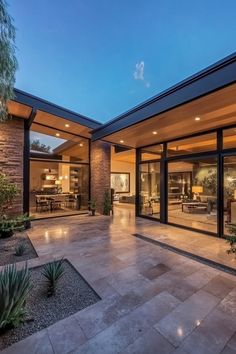 an outdoor living room and dining area with glass doors