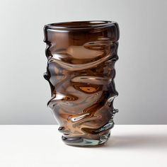 a brown glass vase sitting on top of a table