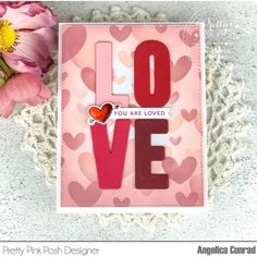 a card with the word love on it next to flowers and crochet doily