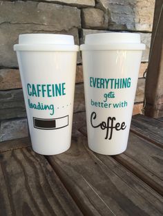 two coffee cups sitting on top of a wooden table