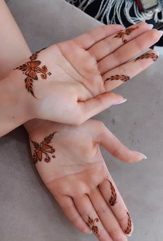 two hands with hendi tattoos on them