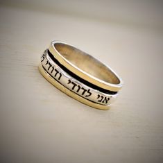 "Spinner Fidget Ring, Handwriting Gift. Made from 925 Sterling Silver Combined with 9K Solid Gold. Width (approx.): 0.8cm (0.31 inches). FREE WORLDWIDE SHIPPING Handmade Original Inscribed Hebrew Spin Ring: \"I am my Beloved's and my Beloved is mine\" (אני לדודי ודודי לי). This inscription is taken from Song of Solomon 6:3 (New King James Version. You have the option to change the spinner ring caption to one of the options listed below, in Hebrew or English: 1. אני לדודי ודודי לי; Iam My Beloved Silvr Rings, Inscribed Rings, Handwriting Gifts, Judaica Jewelry, Dainty Rings, Spinning Rings, Song Of Solomon, New King, Fidget Rings