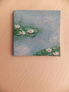 a painting of water lilies on a wooden surface