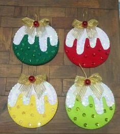 three christmas ornaments are sitting on a wooden floor with sequins and gold bows