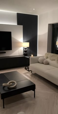 a living room filled with furniture and a flat screen tv mounted to the side of a wall