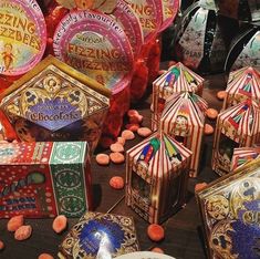 there are many colorful boxes and plates on the table with candy candies in them