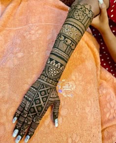 a woman's hand with henna on top of her arm and the wrist