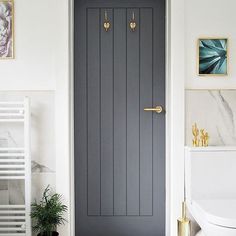 a bathroom with a gray door and white walls