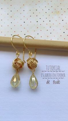 the earrings are made with gold wire and clear glass tears, on top of a white