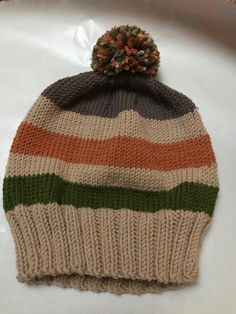 a striped knitted hat with a pom - pom on top