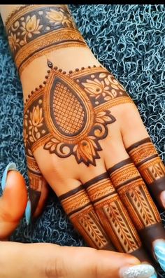 a woman's hand with henna tattoos on it