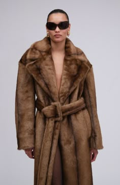 A re-invention of the iconic trench coat takes creative vision. This style aces the interpretation of a recognizable checked pattern, long epaulettes, and a belt to cinch it all together. But the best part is that it’s made from the coziest faux fur.  PRE-ORDER Luxury Long Mink Coat, Luxury Mink Long Coat, Luxury Brown Long Coat, Mink Long Coat For Work, Luxury Brown Belted Outerwear, Chic Mink-colored Formal Outerwear, Chic Mink Outerwear For Formal Occasions, Chic Mink Formal Outerwear, Fur Aesthetic