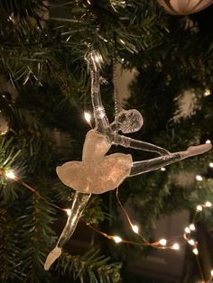 a glass ornament hanging from a christmas tree with fairy lights on the branches