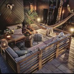 an outdoor living area with hammock, couches and lights on the deck