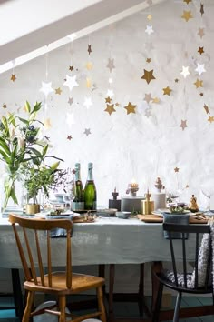 a dining room table with two chairs and a large white star wallpaper behind it