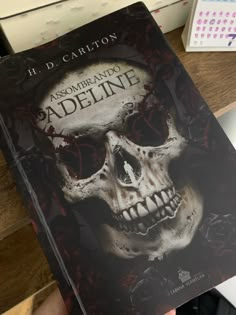 a person holding up a book with a skull on it