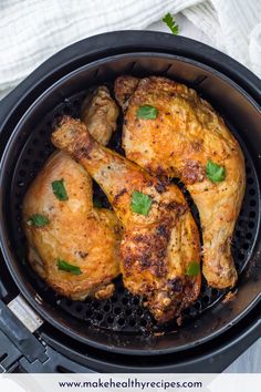 chicken in an air fryer with parsley on the side, ready to be cooked