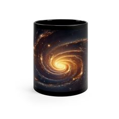 a black coffee mug with an image of a spiral galaxy in the center and stars on it