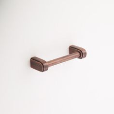 a close up of a metal handle on a white wall with no one around it