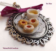 small miniature pastries sitting on a plate with a pink bow around the edge and saucer next to it