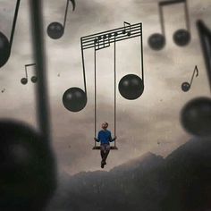 a man is sitting on a swing with musical notes hanging from it's sides