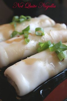 some food is sitting on a black plate with green garnish and seasoning